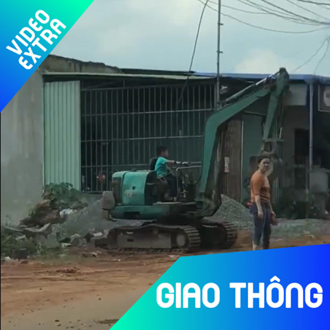 Nguoi phu nu than nhien de be trai lai may xuc sat duong dong hinh anh