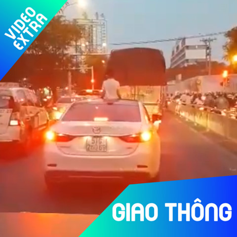 Be trai ngoi vat veo tren noc oto khi xe dang chay hinh anh